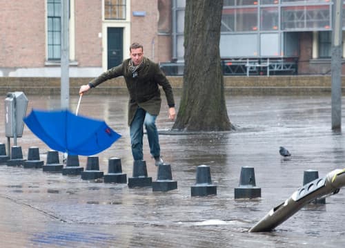 Een man worstelt zich door een najaarsstorm.